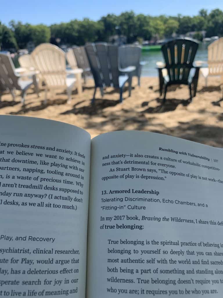 reading a book with lake and beach chairs in background
