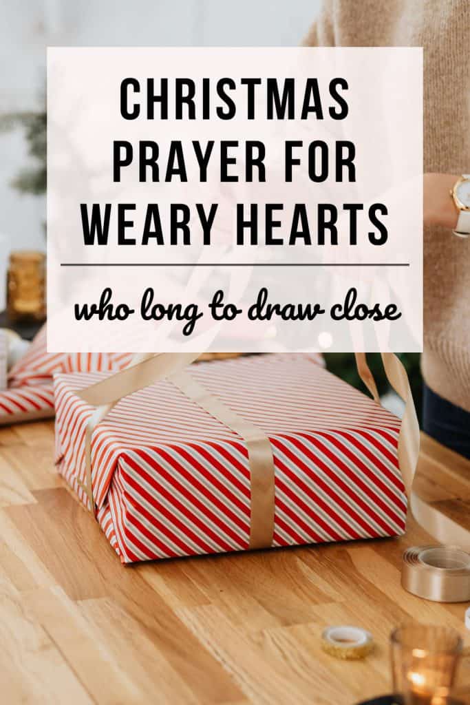 a woman wraps a christmas present in a beautiful package tying on a golden bow. Text overlay reads: Christmas prayer for weary hearts