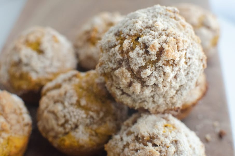 A pile of pumpkin muffins with dusting of sugar