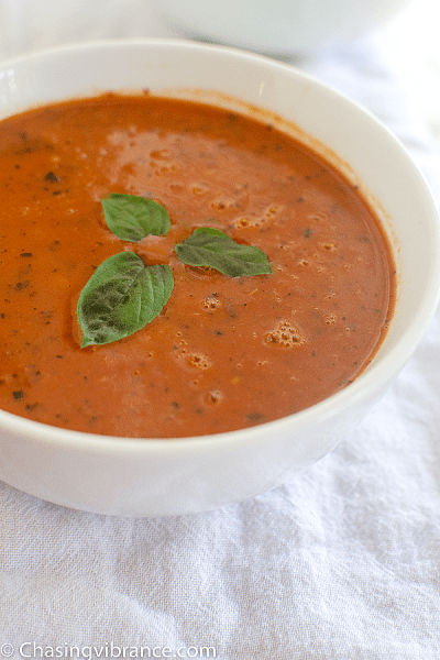 Bowl of vegan tomato soup with basil leaves as garnish