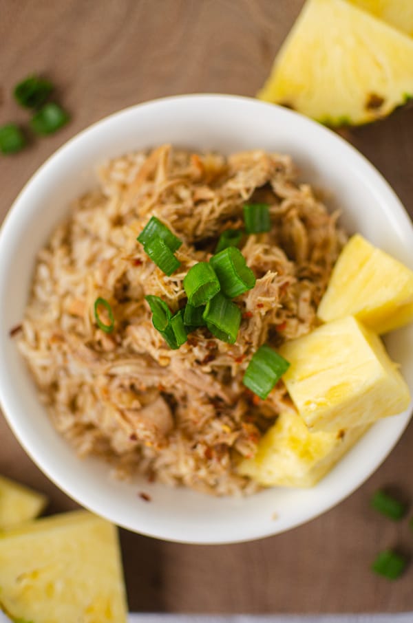 Overhead photo of white bowl filled with rice, hawaiian chicken, pineapple and green onions