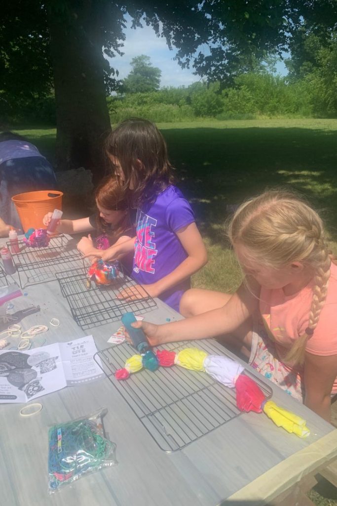Girls tie dye t-shirts in backyard on a picnic table