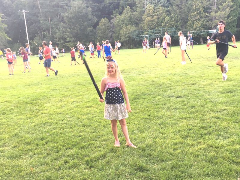 Girl in patriotic shirt plays capture the flag at Gull Lake Ministries family camp