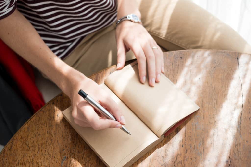 woman readies her pen to write in journal