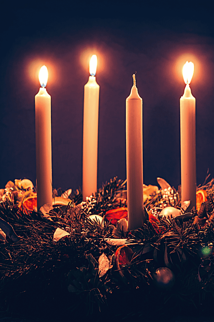 three candles on an advent wreath burn brightly 