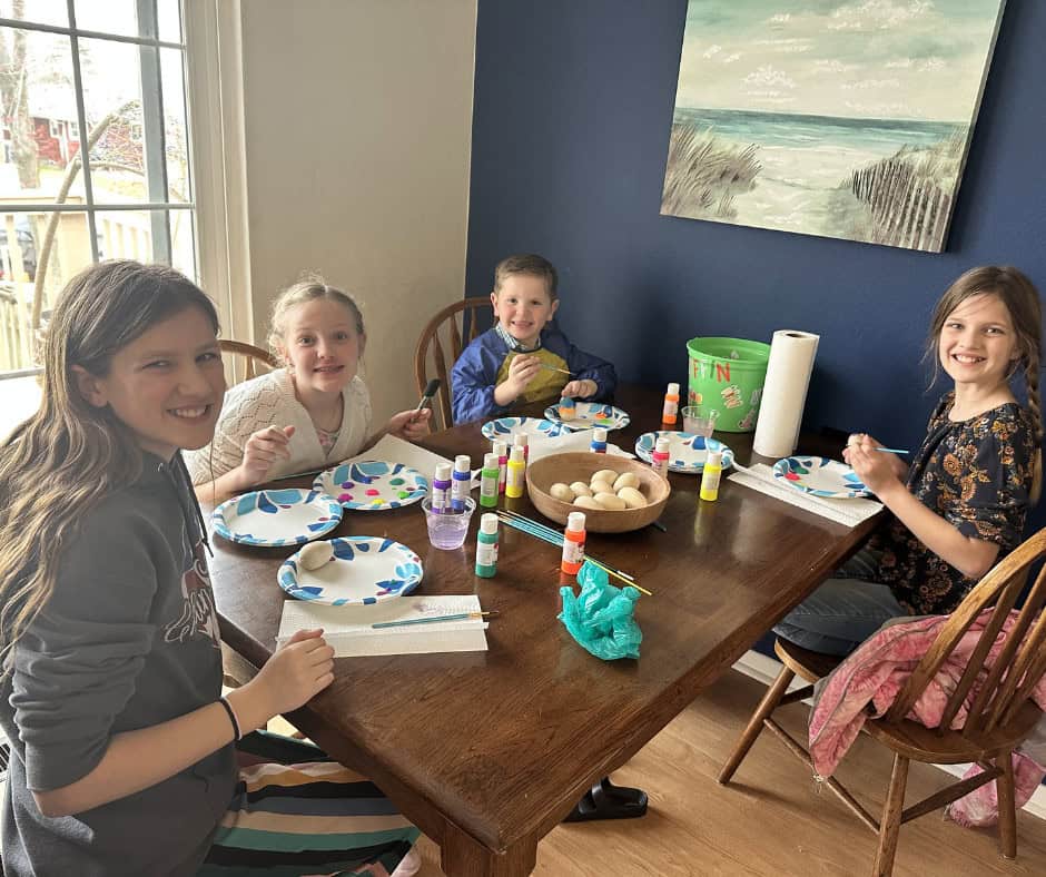 a group of kids participates in an Easter activity--painting wooden eggs