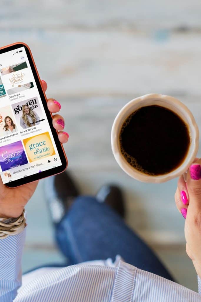 woman holds iphone with Christian women podcasts in her left hand and cup of coffee in her right