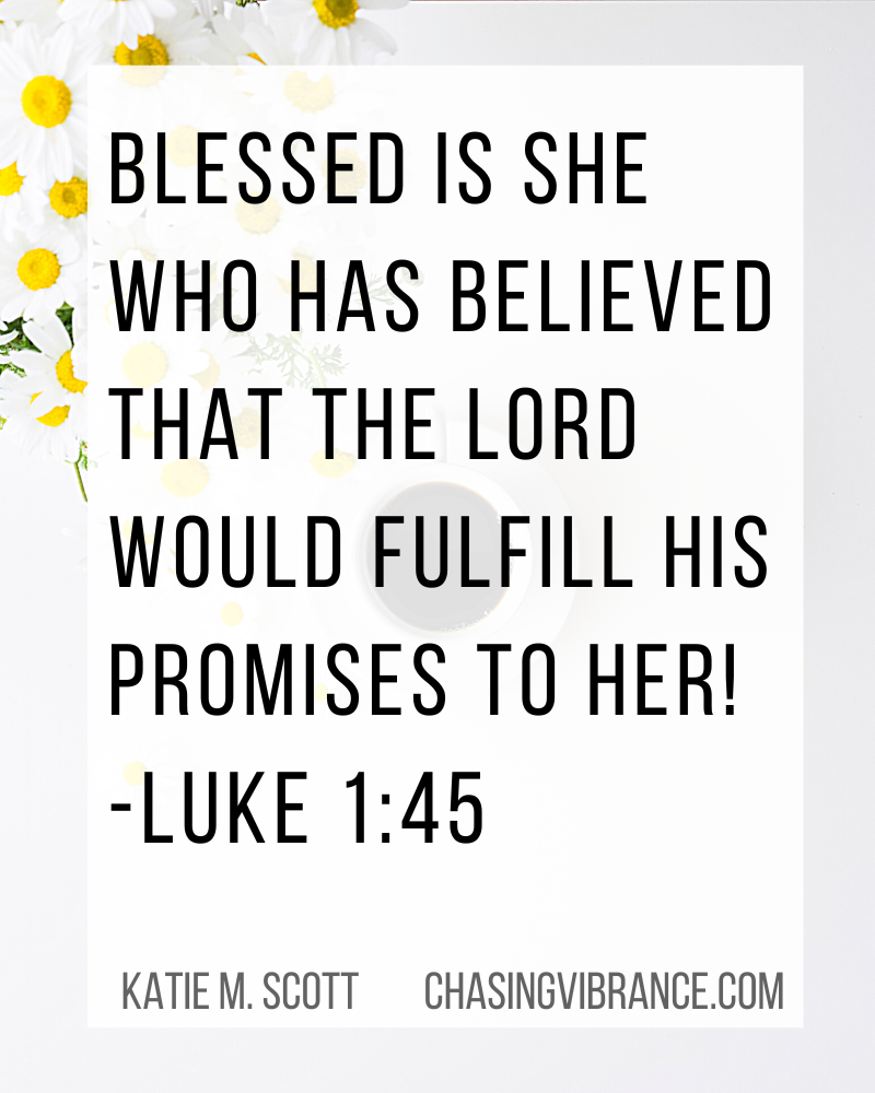 Bright white and yellow daisies on a desk with a cup of coffee in a small white mug in background. Text overlay Bible verse Luke 1:45 Blessed is she who has believed that the Lord would fulfill his promises to her! 