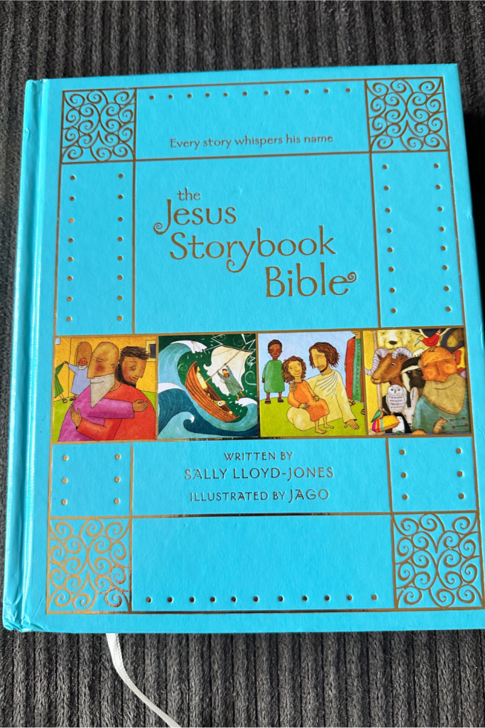 Jesus Storybook Bible hardcover with leather teal blue cover lies on a coach ready for family devotion time